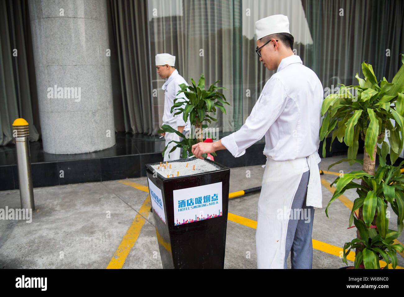 FILE--Chefs smoke cigarettes at the smoking area of a hotel in Shanghai,  China, 1 March 2017. The smoking rate of local residents aged 15 and abov  Stock Photo