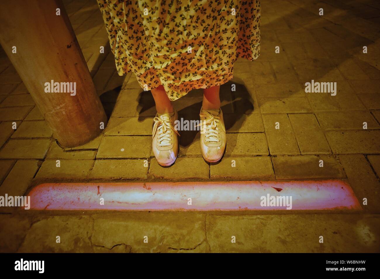 A pedestrian is stopped by the audio and visual devices of a smart zebra crosswalk as she prepares to jaywalk in Tongzhou district, Beijing, China, 6 Stock Photo