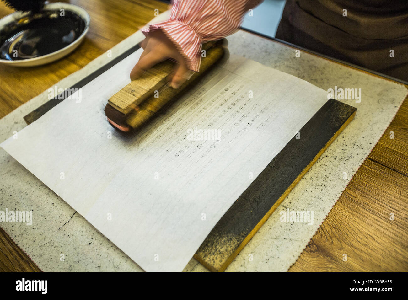 A visitor experiences woodblock printing at the China Bookstore in Beijing, China, 30 April 2018.   A woodblock printing event was held at the China B Stock Photo