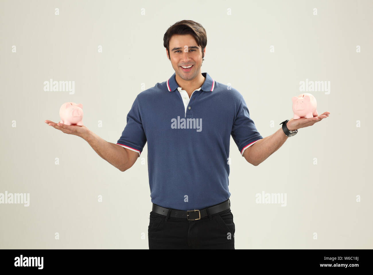 Man showing piggy banks and smiling Stock Photo - Alamy