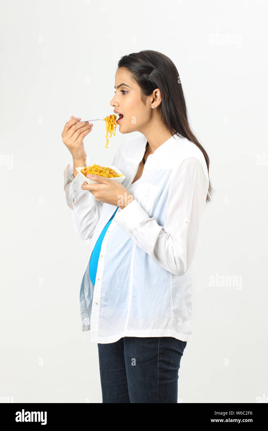 Pregnant woman eating noodles Stock Photo