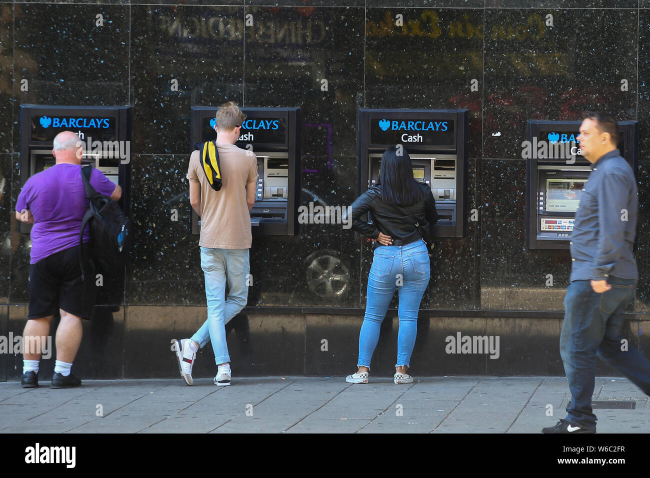People Use The Atm Machines Outside Barclays Bank In London Stock