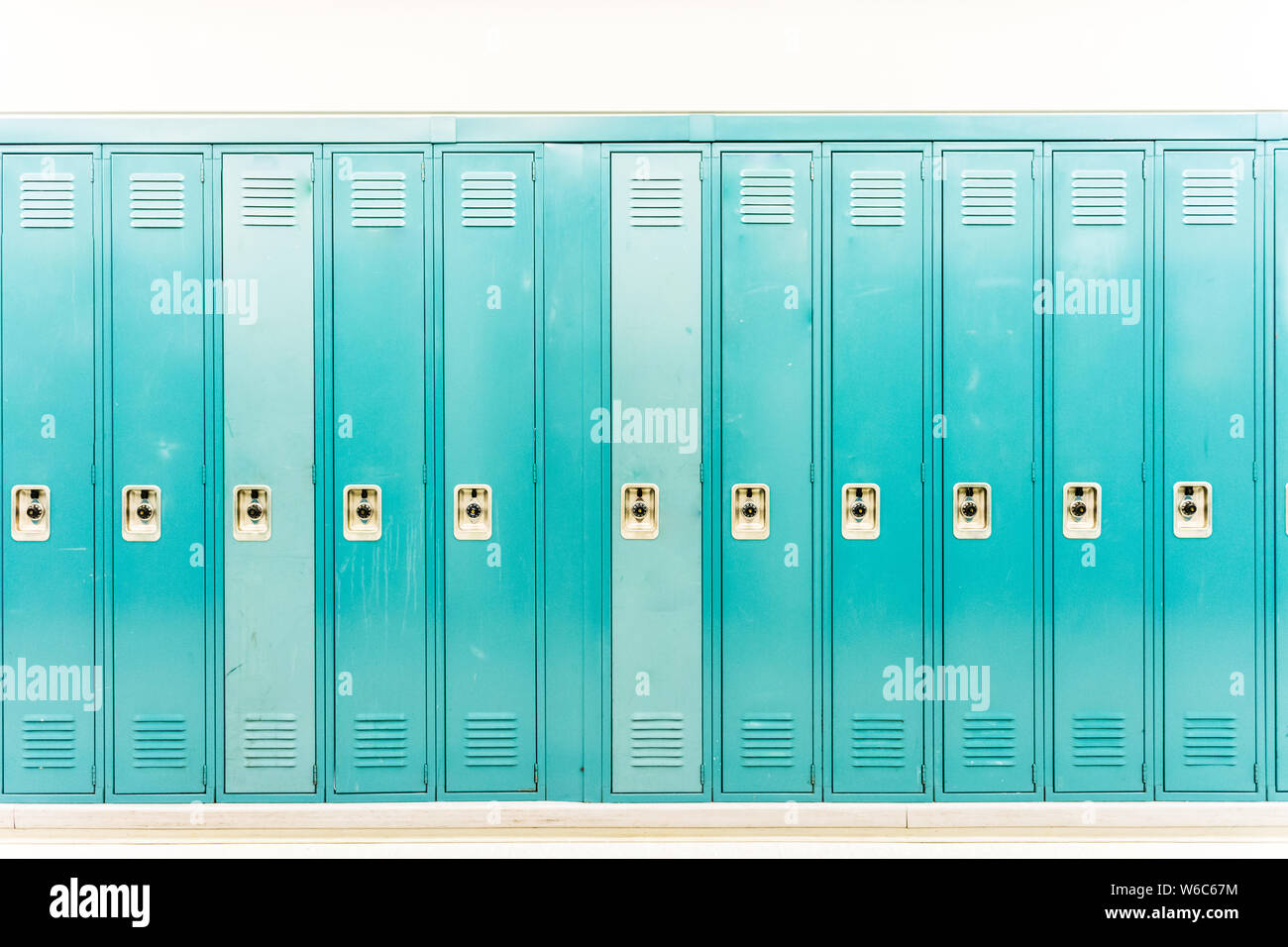 Worn down turquoise school lockers straight on Stock Photo