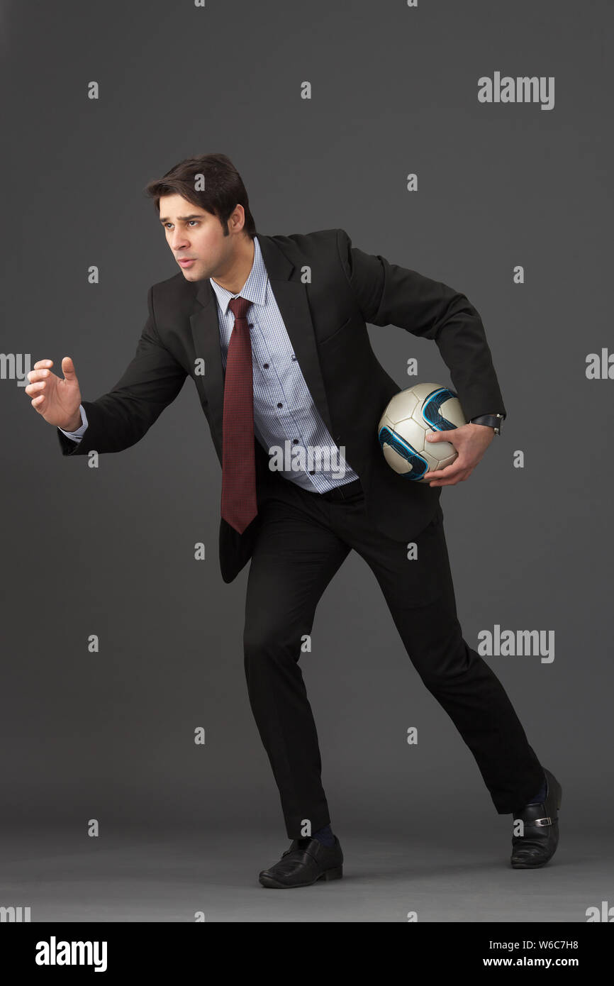 Businessman playing soccer ball Stock Photo - Alamy
