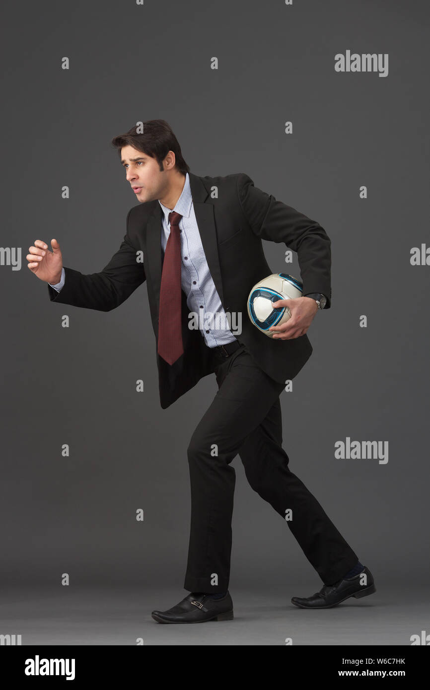 Businessman playing soccer ball Stock Photo - Alamy