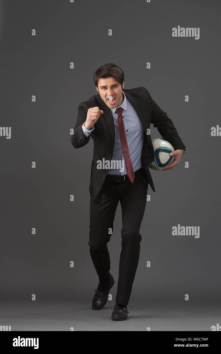 Businessman playing soccer ball Stock Photo - Alamy