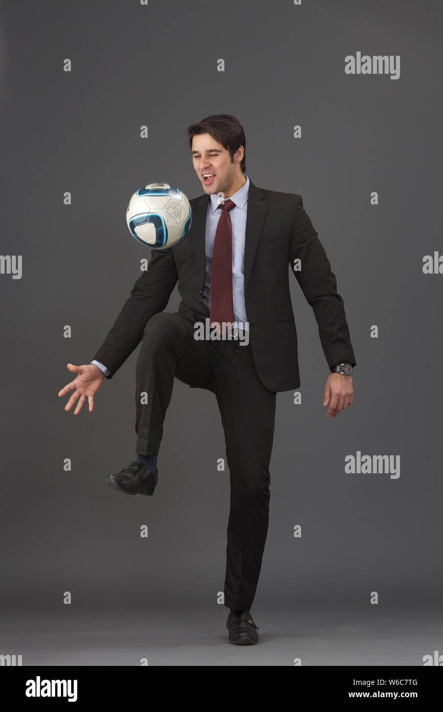 Businessman playing with soccer ball Stock Photo - Alamy