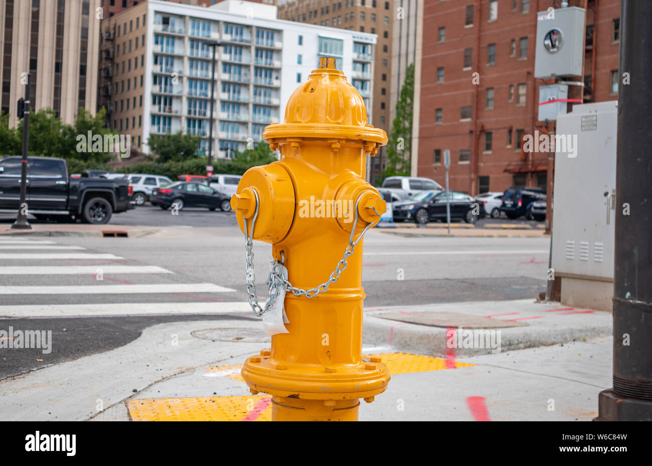 Fire fighting public system. Fire hydrant yellow color painted outdoors in the city center, sunny spring day Stock Photo