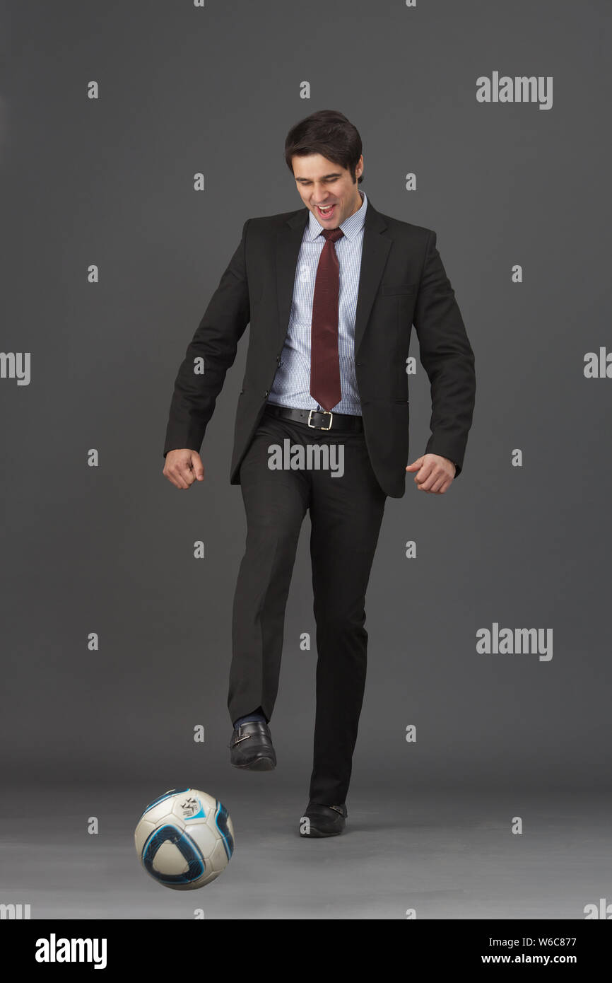 Businessman playing with soccer ball Stock Photo - Alamy