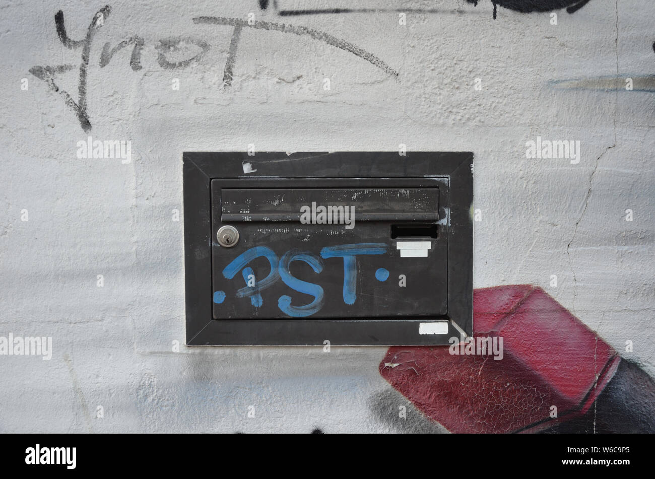 Black letterbox on white wall wit graffiti Stock Photo