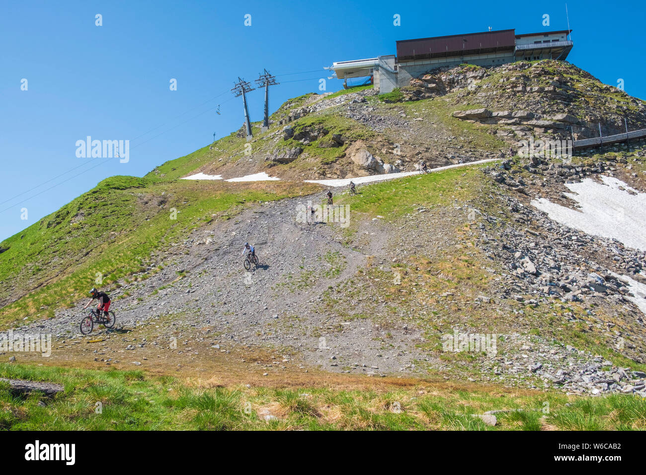 Mountain bikers at the Portes du soleil, Switzerland, riding down a steep gravel ramp. Stock Photo