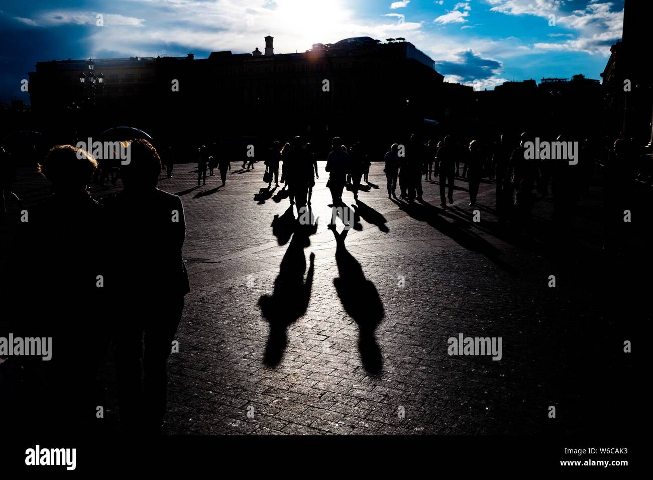 Silhouettes of people walking on the streets during sunset Stock Photo ...
