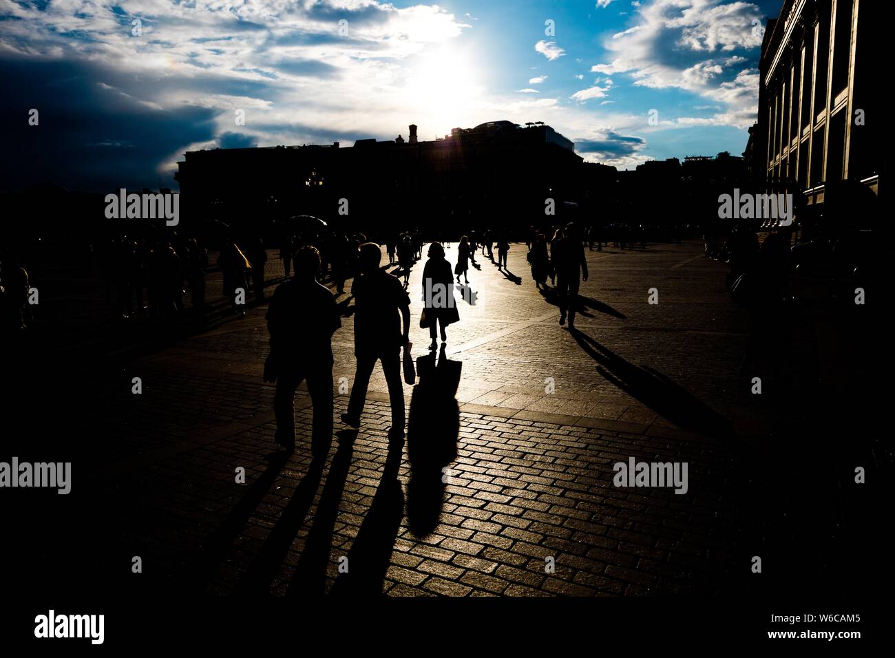 Silhouettes of people walking on the streets during sunset Stock Photo ...