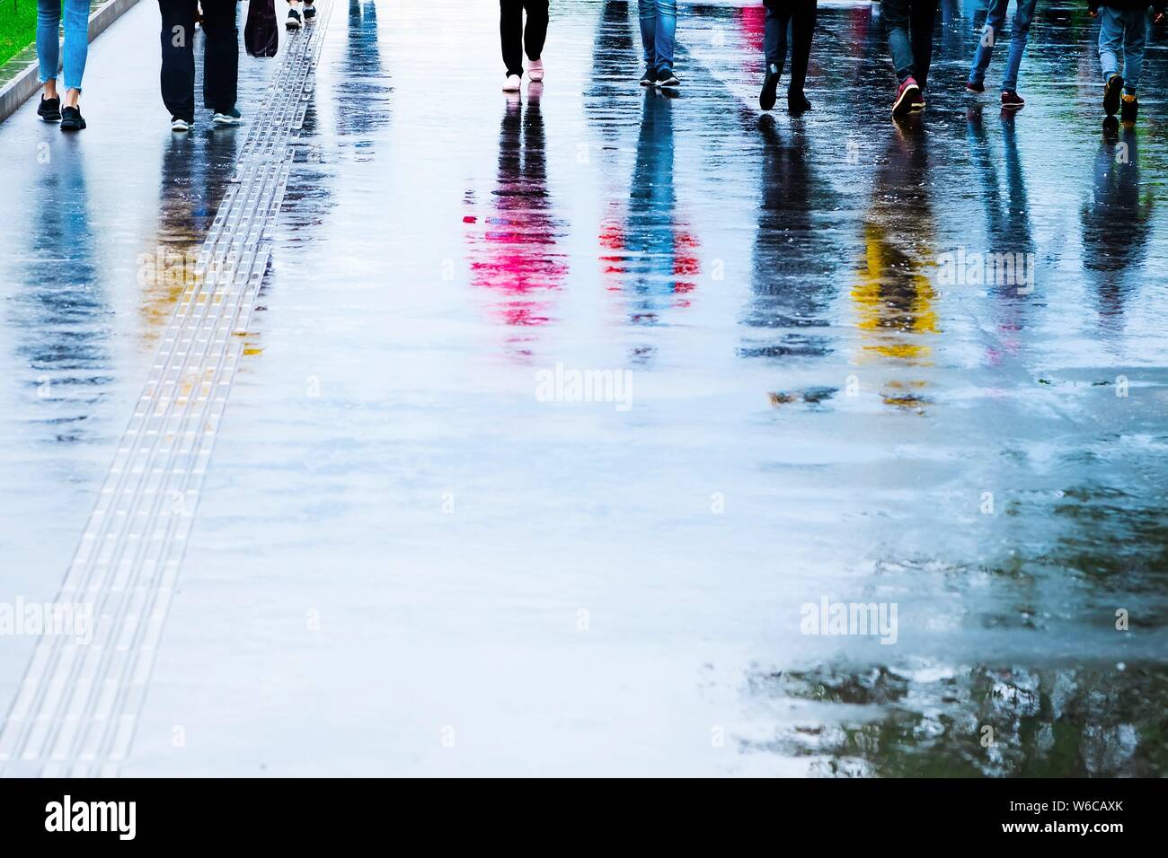 Reflection of people walking on the street after rain Stock Photo - Alamy
