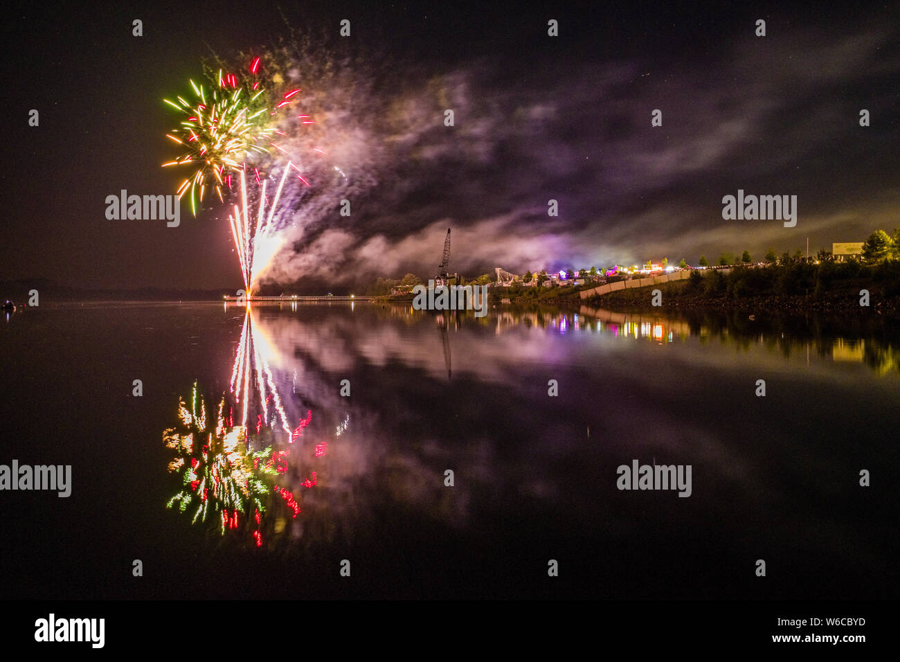 Colorful fireworks are reflected in a lake at night Stock Photo