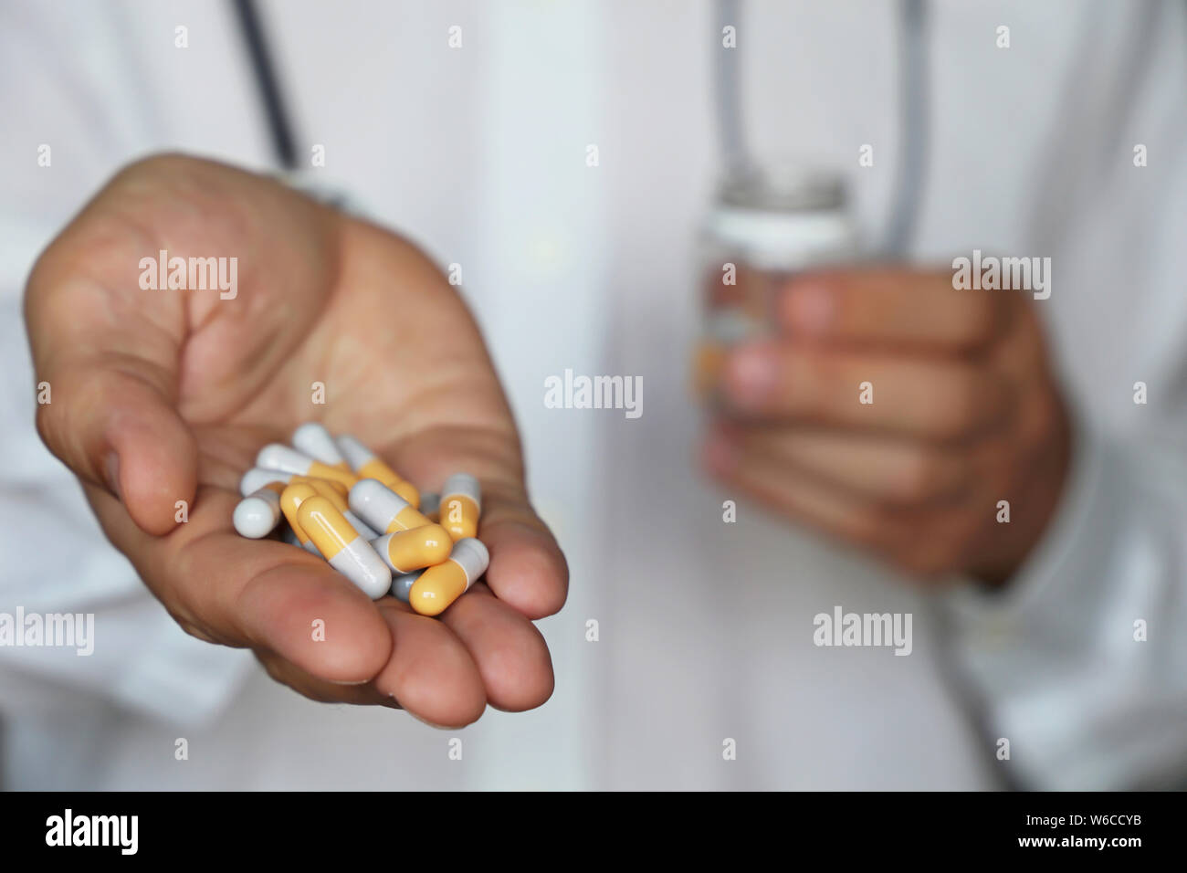 Doctor giving pills, physician holding in palm of hand medication in capsules. Concept of dose of drugs, vitamins, medical exam, pharmacy Stock Photo