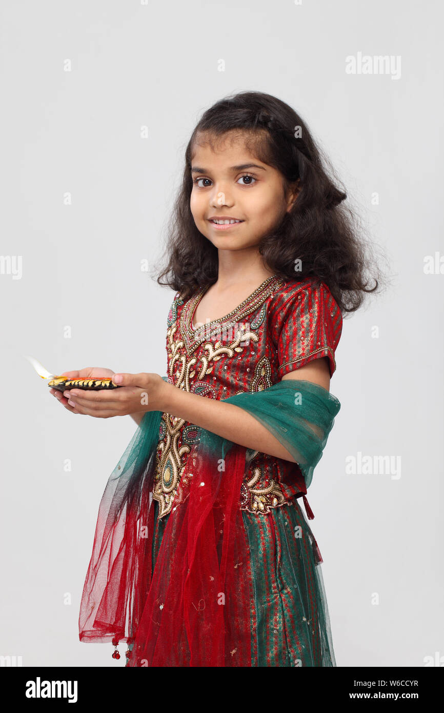 Portrait of a girl holding diya and smiling Stock Photo