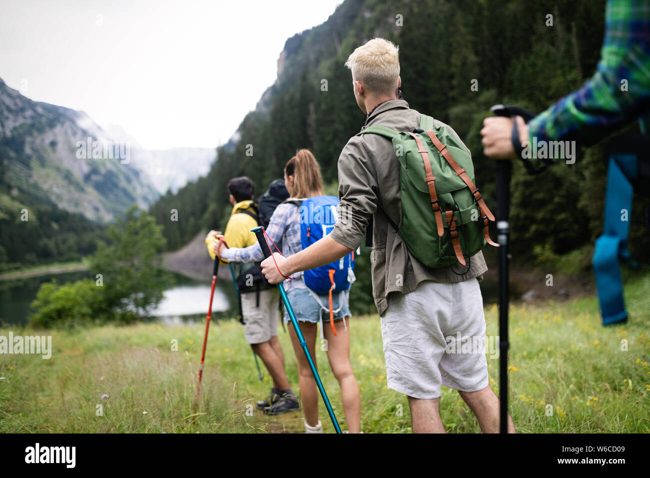 Group of young friends hiking in countryside. Multiracial happy people ...