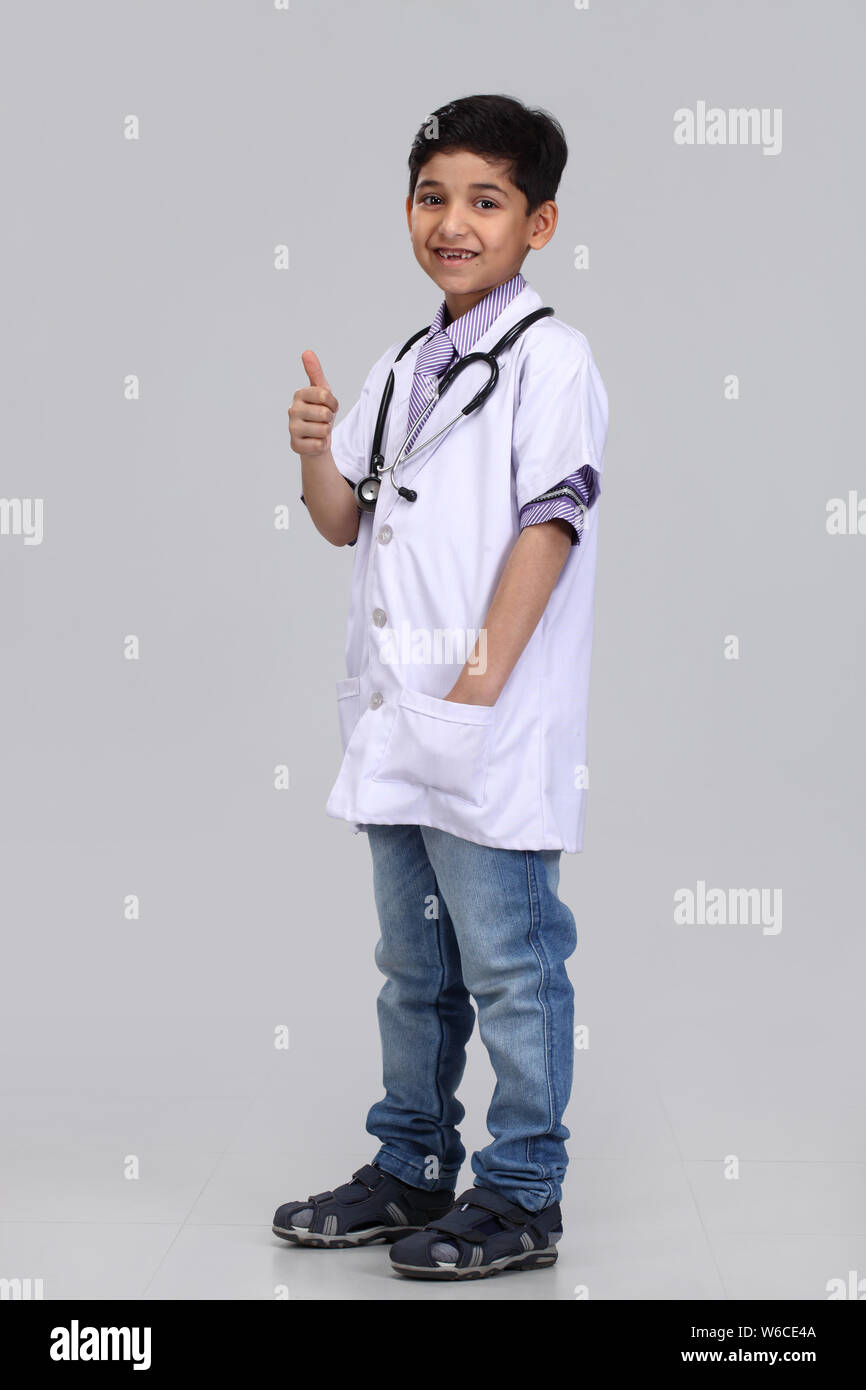 Boy pretending to be a doctor and showing thumbs up sign Stock Photo