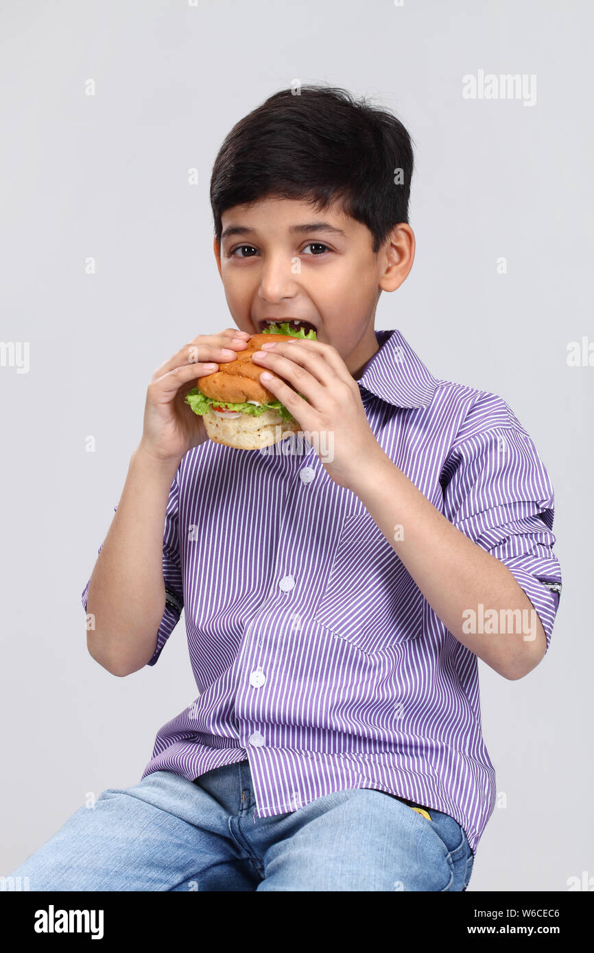 Boy eating a burger Stock Photo Alamy