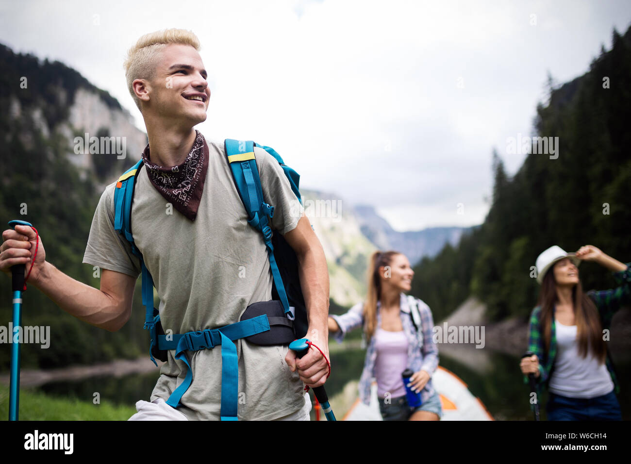 Group of young friends hiking in countryside. Multiracial happy people ...