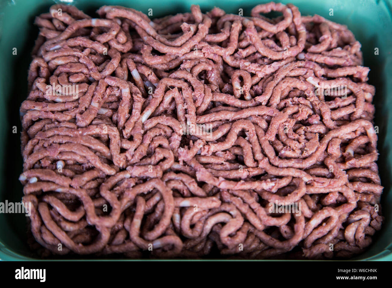 Close up image of vegan meat in plastic container. Looks like minced beef, pork, veal. Uncooked
