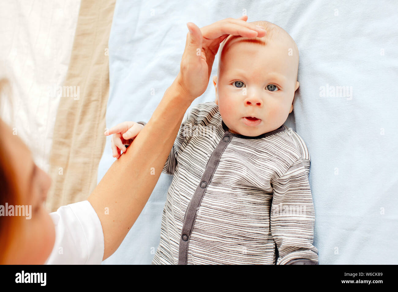 Nurse examining head of cute newborn baby Stock Photo