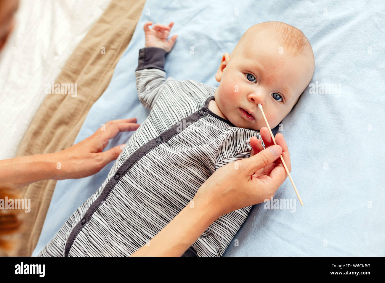 Mother cleaning nose to adorable baby Stock Photo