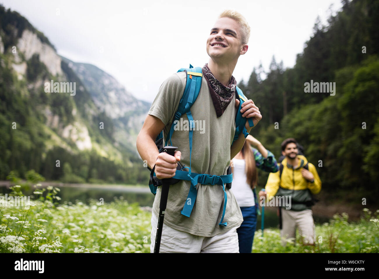 Group of happy friends with backpacks hiking together Stock Photo - Alamy