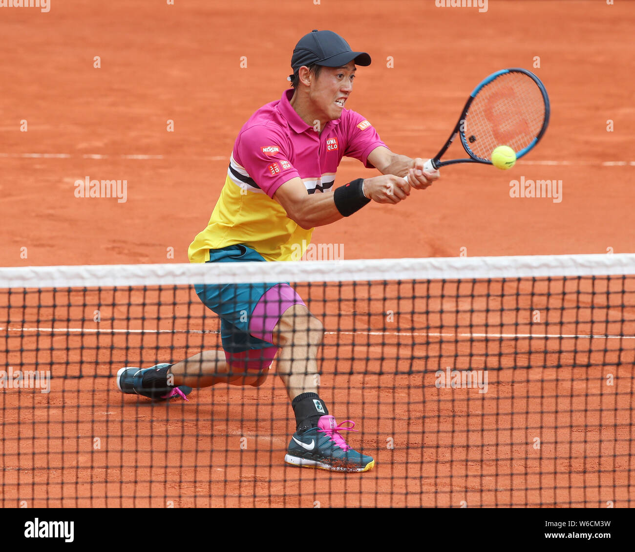 Japanese tennis player Kei Nishikori playing backhand volley shot in French Open 2017 tennis