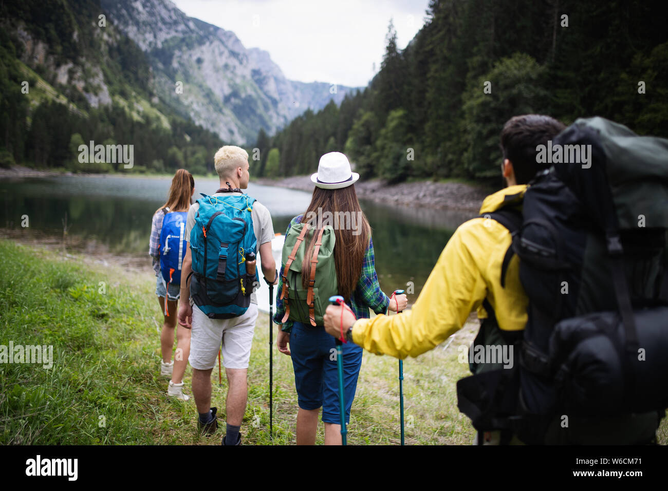 Group of young friends hiking in countryside. Multiracial happy people ...