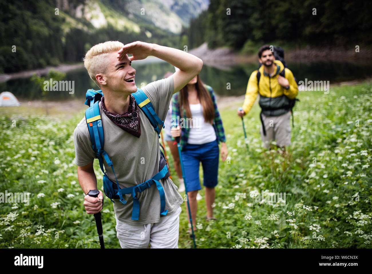 Group of happy friends with backpacks hiking together Stock Photo - Alamy
