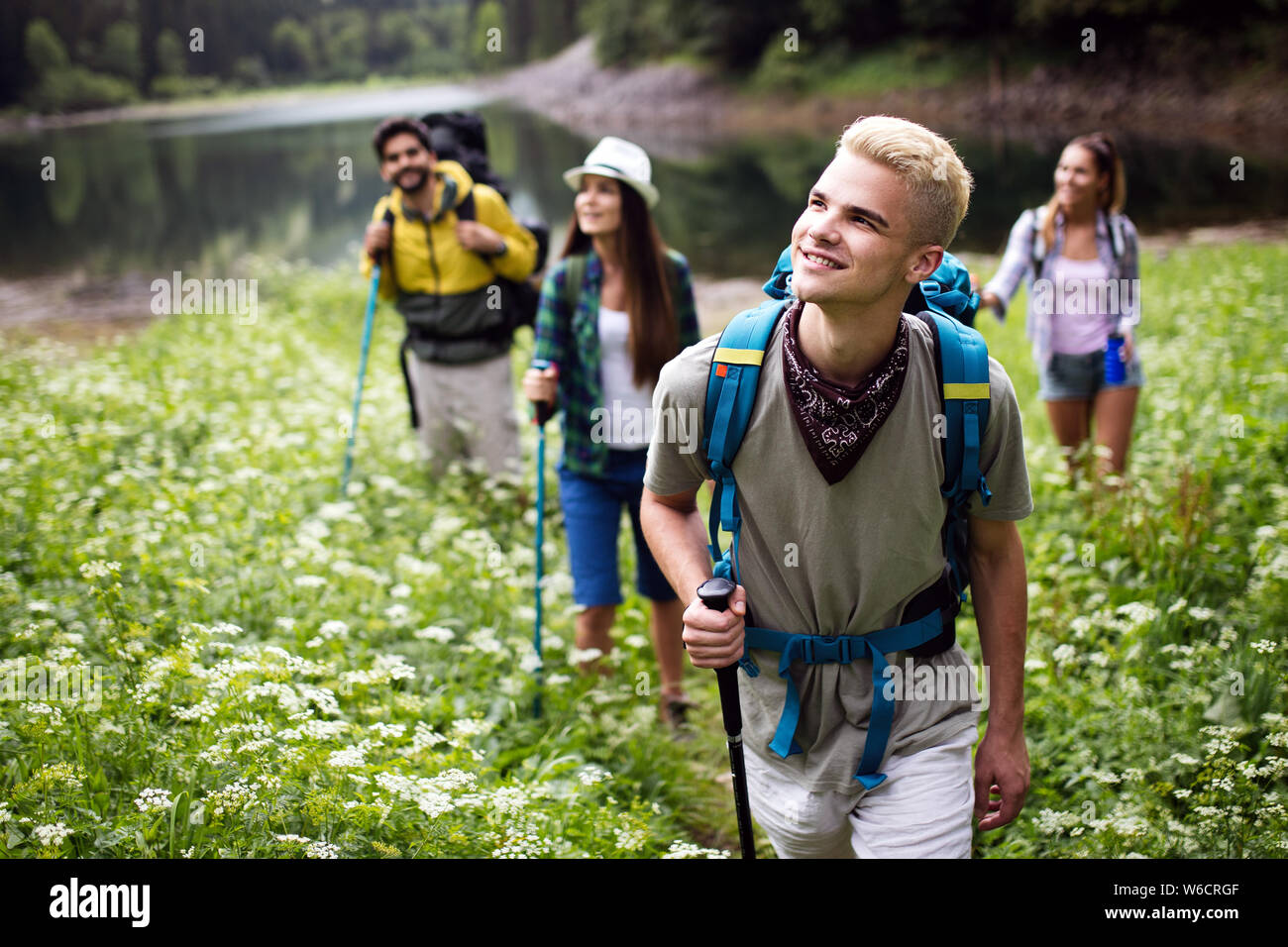 Group of young friends hiking in countryside. Multiracial happy people ...