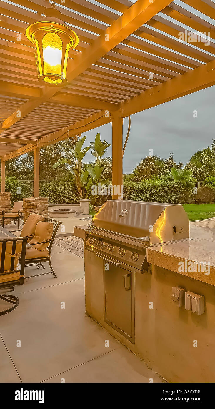 Vertical Outdoor Kitchen And Dining Area Under A Pergola At