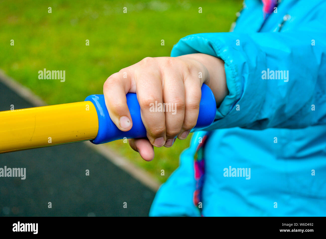 Close up of child hand holding handle of children's sports equipment on