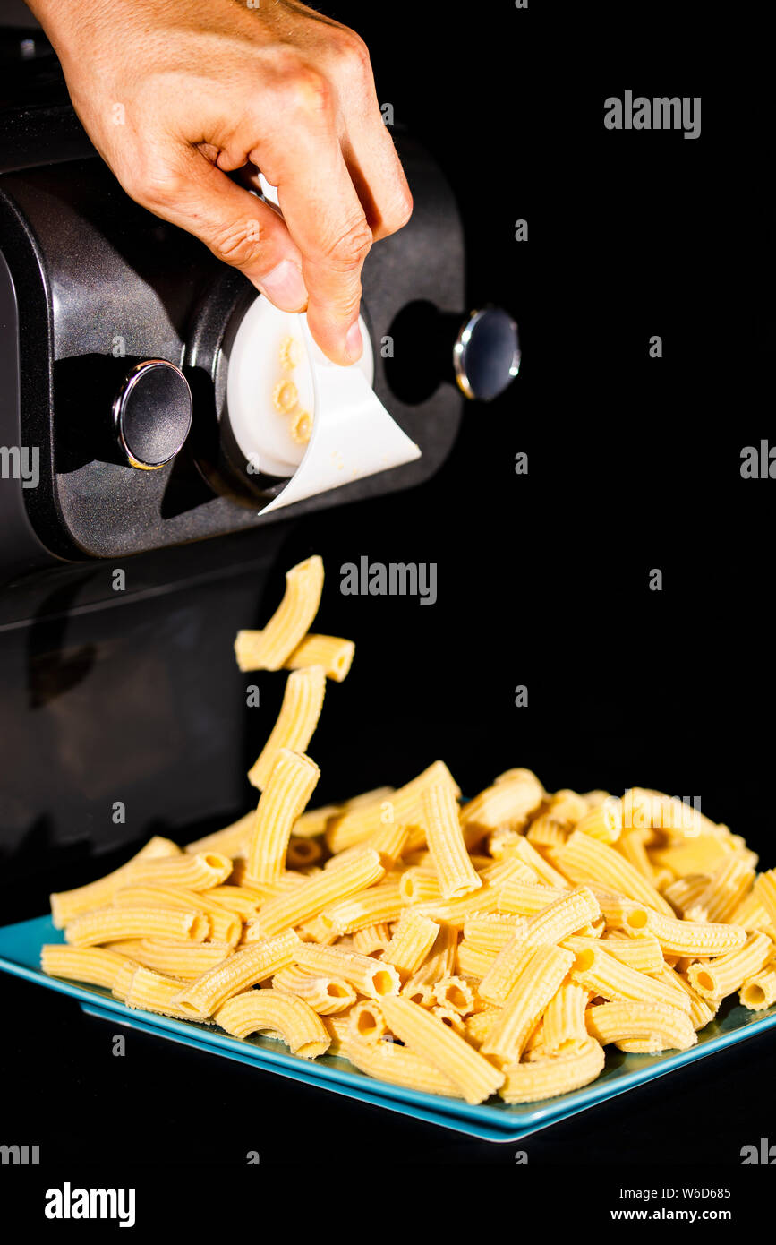 https://c8.alamy.com/comp/W6D685/preparing-home-made-rigatoni-with-eggs-pasta-by-pasta-maker-close-up-photo-on-black-background-copy-space-W6D685.jpg