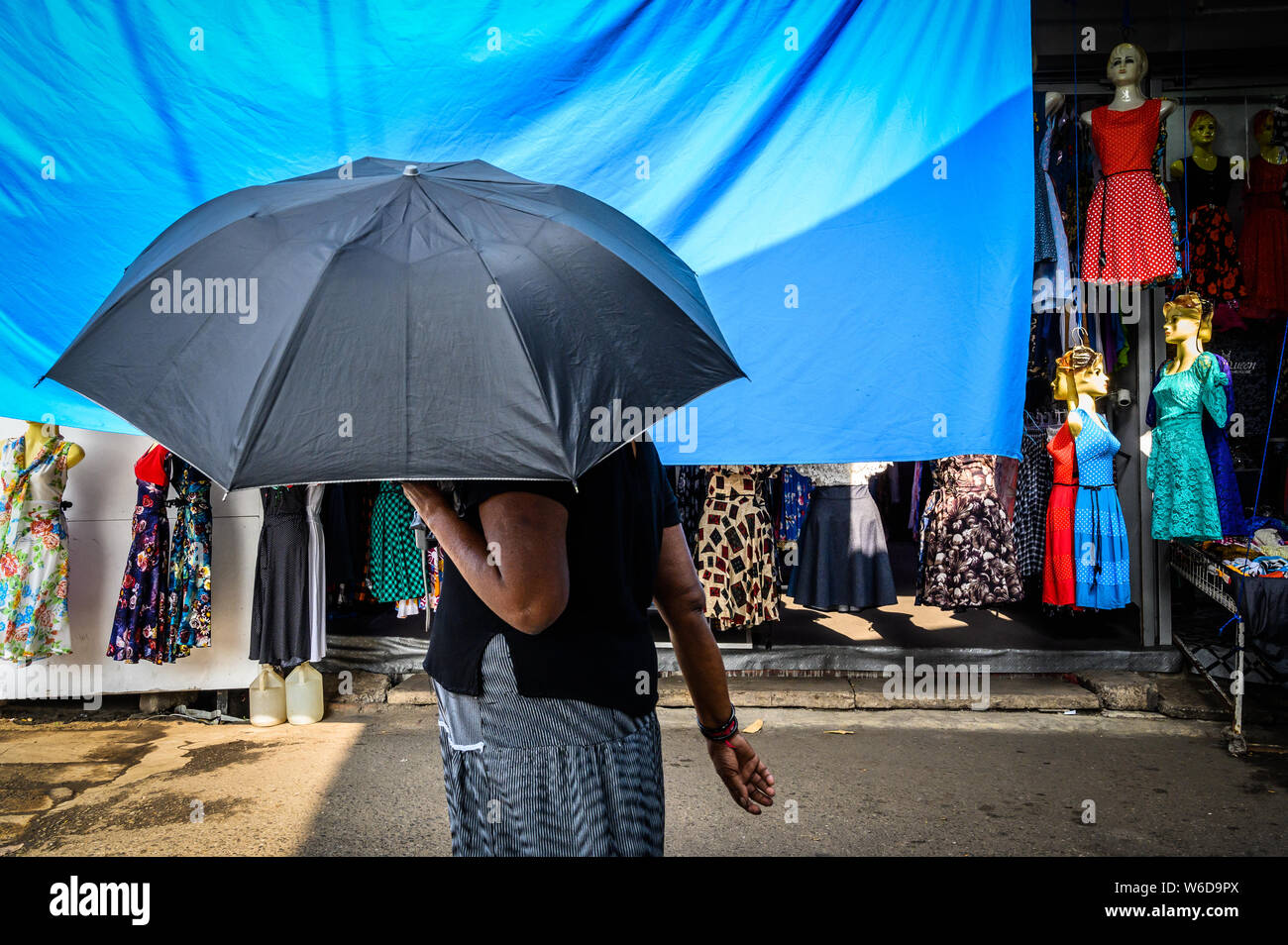 A woman with an umbrella on a shopping street in Negombo, Sri Lanka Stock Photo