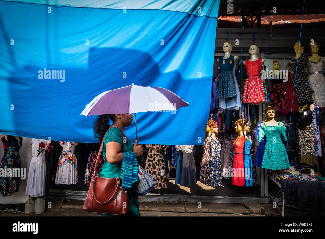 A woman with an umbrella on a shopping street in Negombo, Sri Lanka Stock Photo