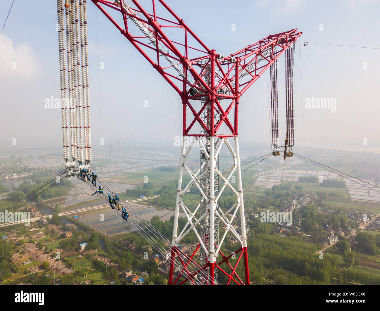 Chinese workers labor at the construction site of the Changji-Guquan UHVDC (ultra-high voltage direct current) transmission link along the Yangtze Riv Stock Photo