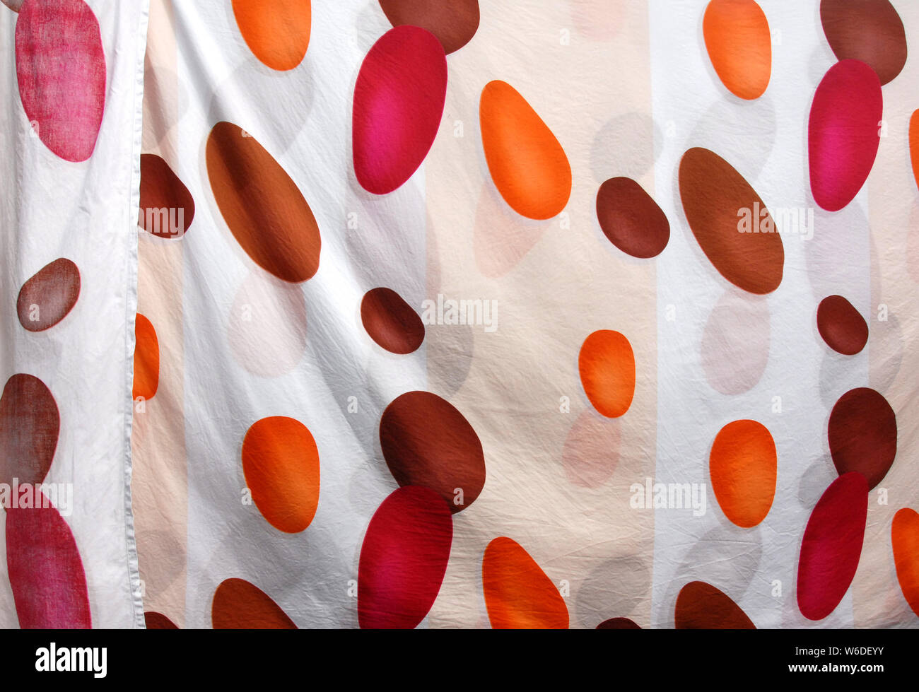 Colorful material for use as a background. White with red, orange and brown spots. Colors are round, oval or egg-shaped. Elliptical Red, orange, brown Stock Photo