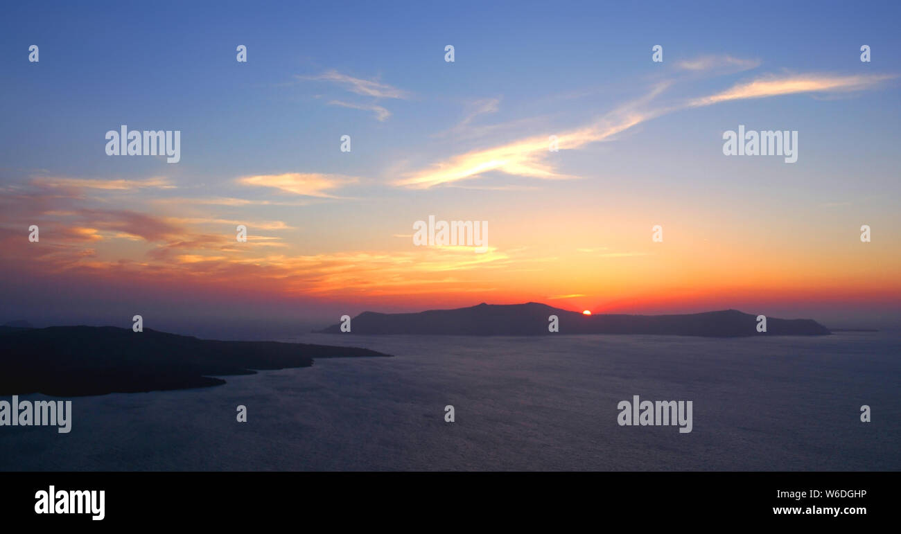 A beautiful sunset from Fira, Santorini Greece. This Santorini sunset is over the caldera. Santorini is famous for its sunsets. Fira, red setting sun. Stock Photo