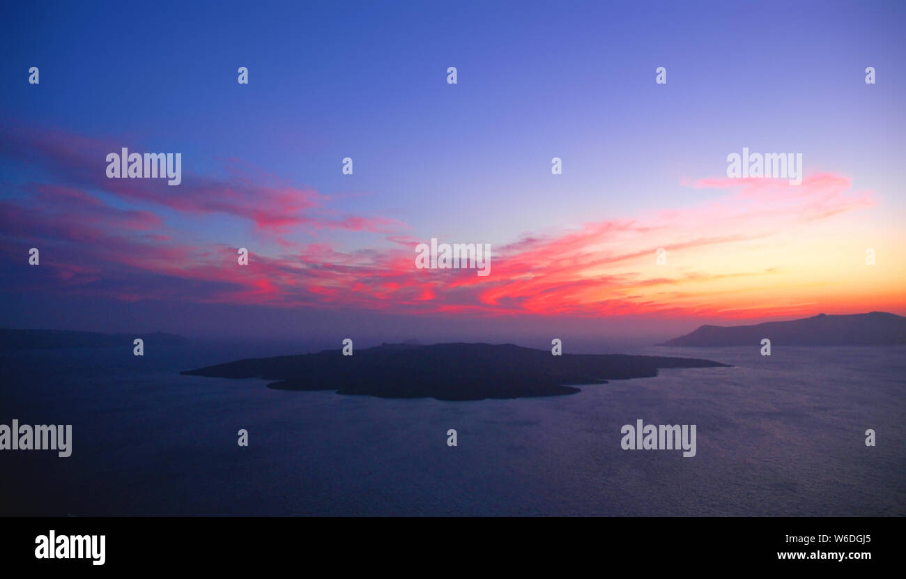 A beautiful sunset from Fira, Santorini Greece. This Santorini sunset is over the caldera. Santorini is famous for its sunsets. Fira, red setting sun. Stock Photo