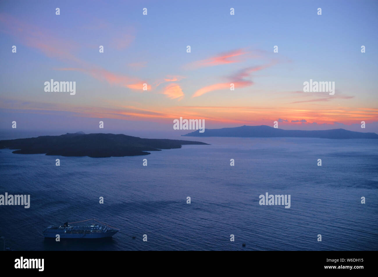 A beautiful sunset from Fira, Santorini Greece. This Santorini sunset is over the caldera. Santorini is famous for its sunsets. Fira, red setting sun. Stock Photo