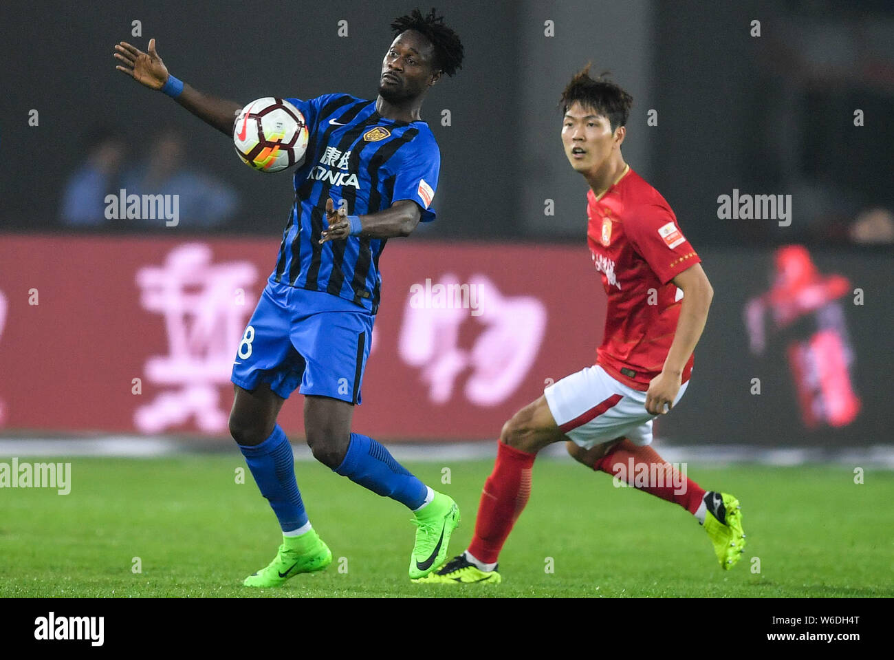 Ghanaian football player Richmond Boakye of Jiangsu Suning, left, controls the ball against South Korean football player Kim Young-gwon of Guangzhou E Stock Photo