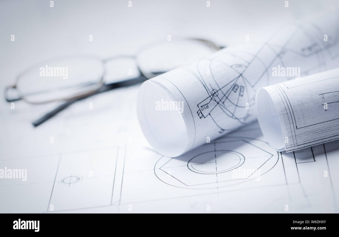 Rolls of drawings with glasses in the background Stock Photo