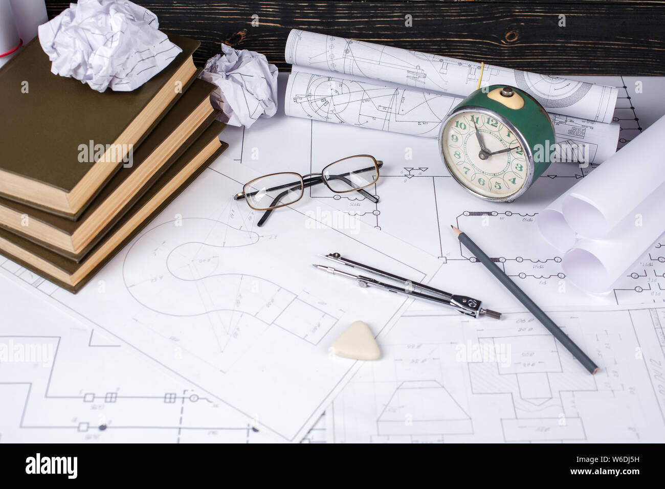 Several tools for drawing, glasses and retro clock lying in the drawings Stock Photo