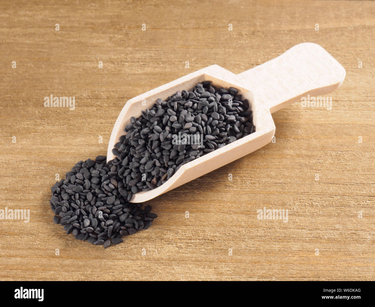 Black sesame (Sesamum indicum) in a scoop on a wooden background diagonally Stock Photo