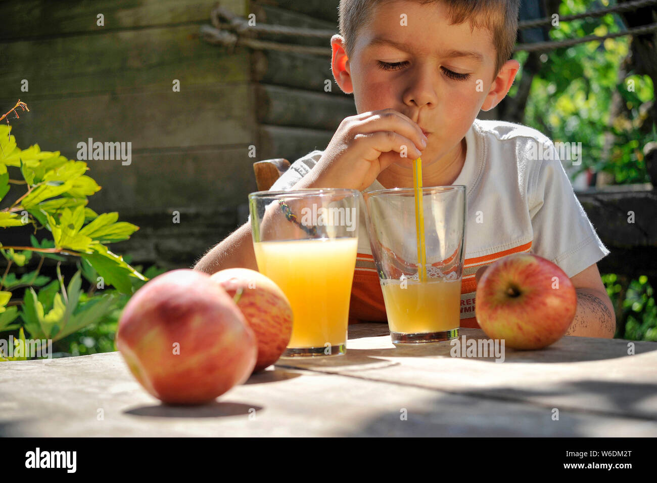 Boy drinking a fruit juice with a straw. NOTICE: Authorization for any editorial use respecting the caption and context of the image and not infringin Stock Photo