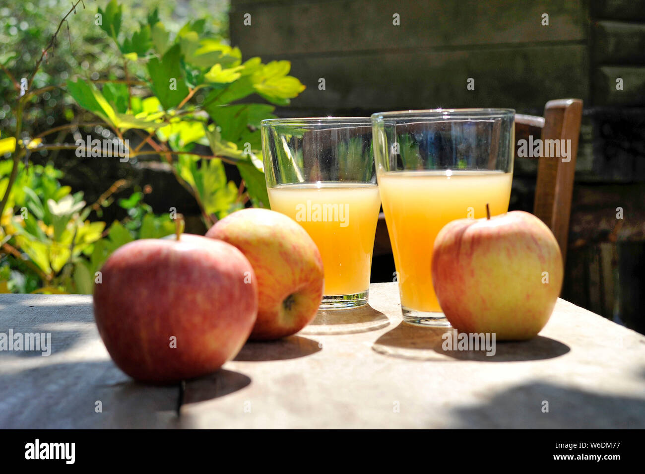 Apples and glasses of apple juice. NOTICE: Authorization for any editorial use respecting the caption and context of the image and not infringing or d Stock Photo