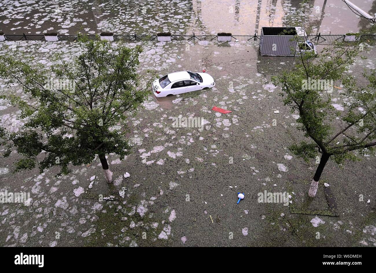 Cars drive through a flooded street after a heavy hailstorm in Bijie city, southwest China's Guizhou province, 21 April 2018. Stock Photo